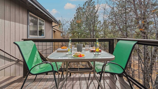 A deck with a table set for two, chairs, and a bottle of water. - Pine Cliff (Flagstaff)