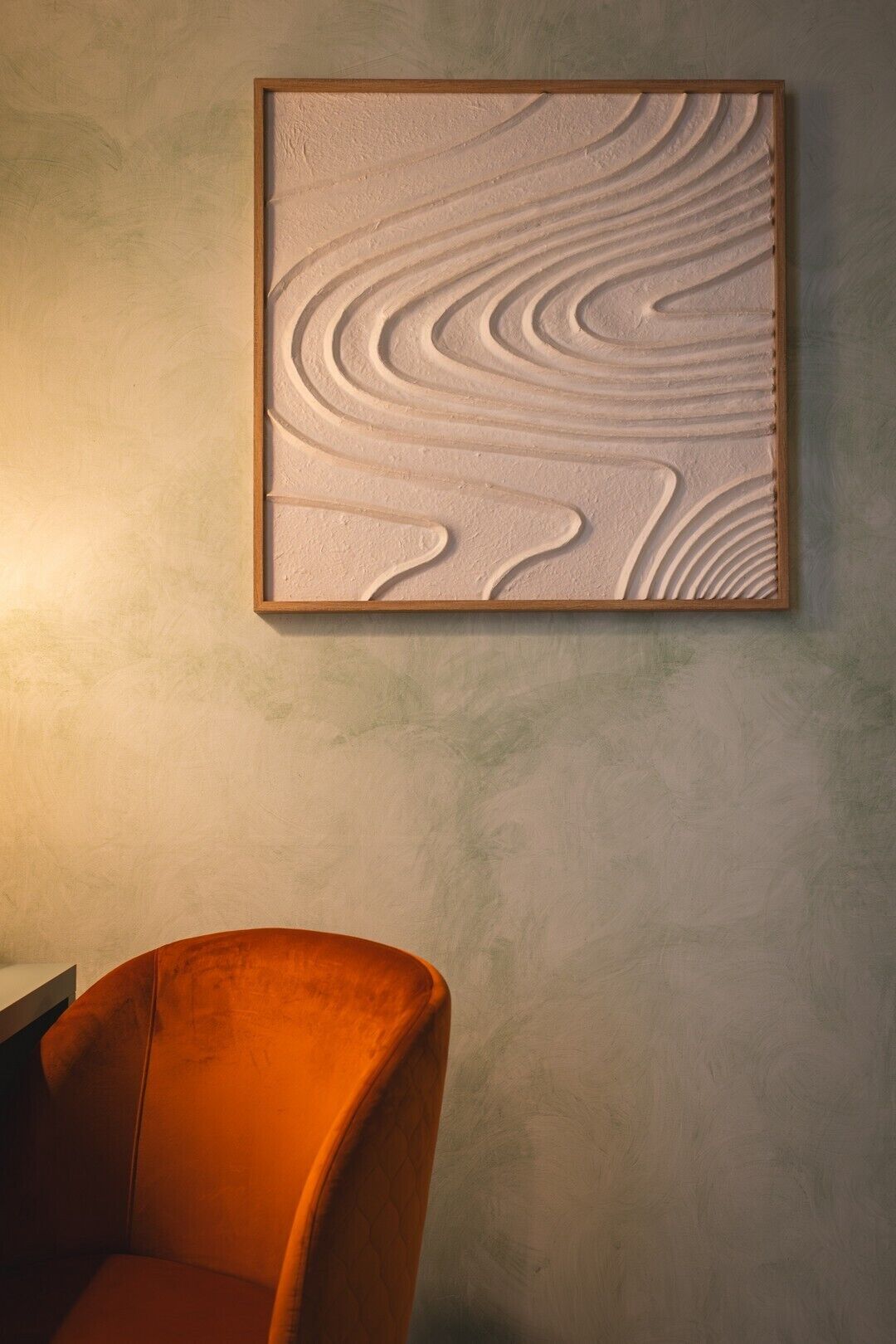 A framed textured wall art piece with a wavy pattern.
