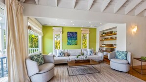 Amplia sala de estar con una pared verde de acento, un amplio sofá y una mesa de centro.