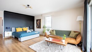 Un dormitorio moderno con cama, sofá, mesa de centro y mesita de noche.