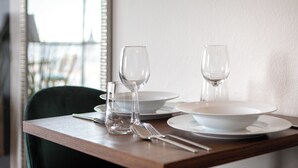 Mesa de comedor servida con platos, tazones, vasos y cubiertos.
