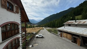 Una strada che si snoda attraverso una zona montuosa, fiancheggiata da edifici.