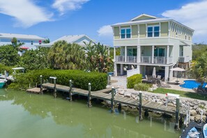 A waterfront property with a dock, a pool, and a multi-level house. - Adventures in Sombrero ~ Pet Friendly, Private Pool, 26' Dock (Marathon)