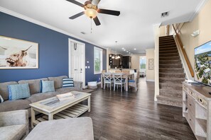 A living room with a sofa, coffee table, and a ceiling fan. - Adventures in Sombrero ~ Pet Friendly, Private Pool, 26' Dock (Marathon)