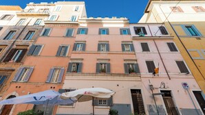 Un immeuble à plusieurs étages doté de balcons et de fenêtres, un lampadaire et un panneau indiquant qu’il est interdit de se garer.
