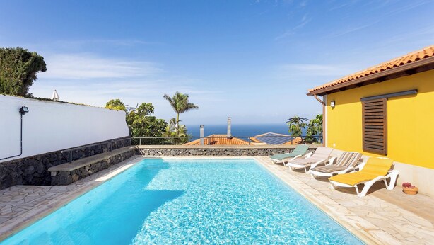 A swimming pool with lounge chairs and a view of the sea. - Home2Book Coastal Dream Villa in Tacoronte (Tacoronte)