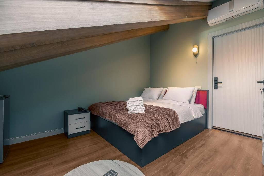 Une chambre à coucher avec un lit, une table de chevet et un luminaire fixé au mur.