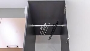 Une petite cuisine équipée d’un four à micro-ondes, d’une pile de serviettes pliées et d’un étendoir.