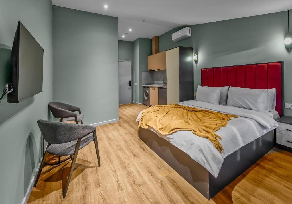 Une chambre à coucher moderne avec un grand lit, un bureau et une chaise.