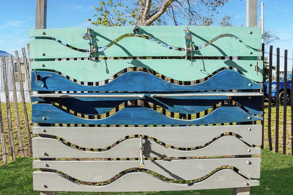 A wooden bench with a wave design. - Sea Hook (Port St. Joe)