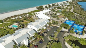 Ein Luftbild eines Resorts mit Strand, Schwimmbecken und Parkplatz.