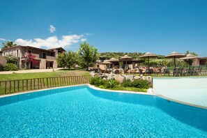 Una piscina al aire libre de temporada, sombrillas, tumbonas