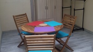 Un coin repas avec une table ronde et quatre chaises en bois dotées de coussins bleus.