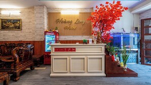 Una recepción con un fondo de madera, un refrigerador de Coca-Cola y un gran arce rojo.