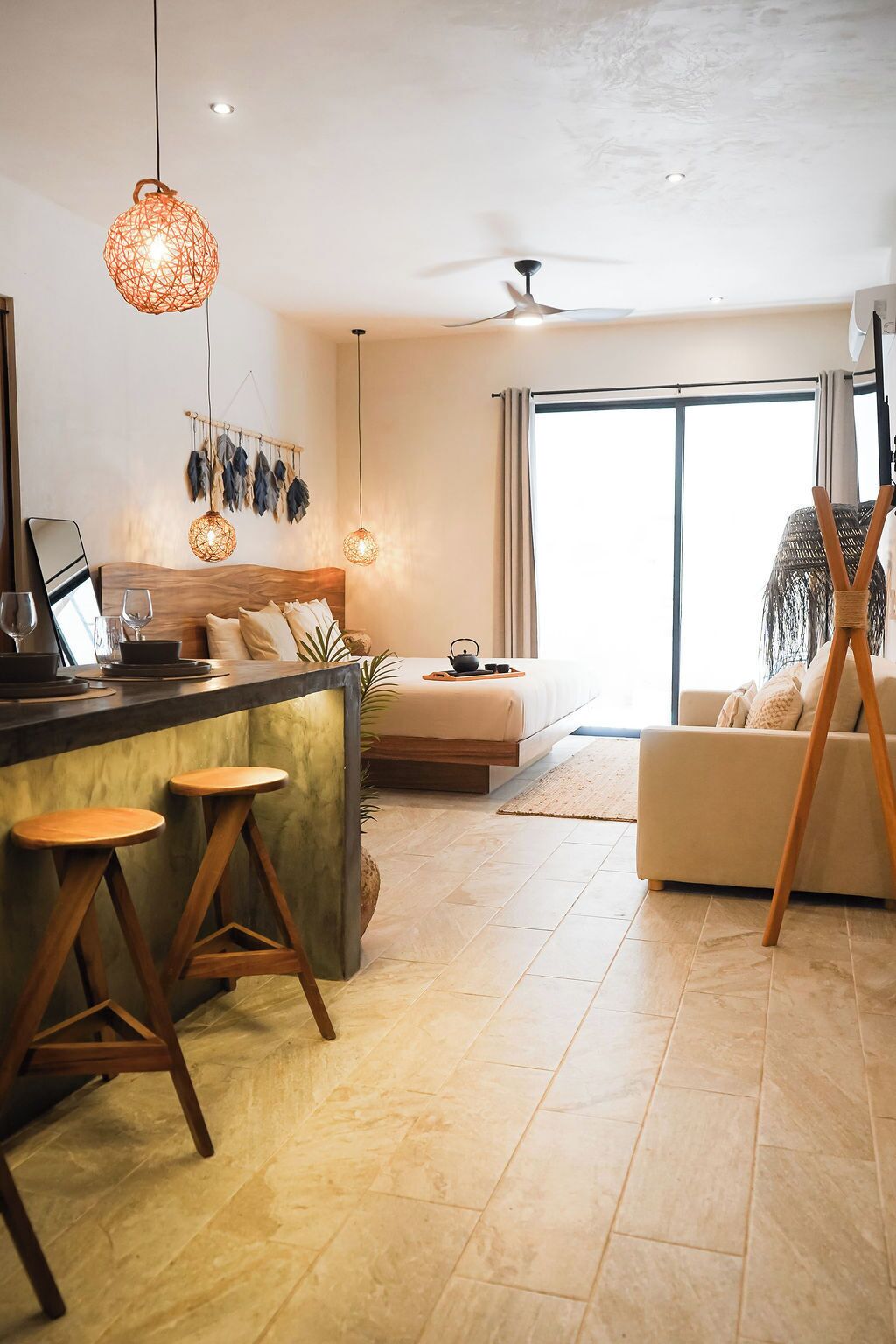 Una sala de estar moderna con un sofá, una mesa de centro y un comedor con taburetes.