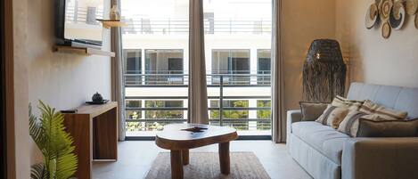 A modern living room with a sofa, a wooden coffee table, and a potted plant.