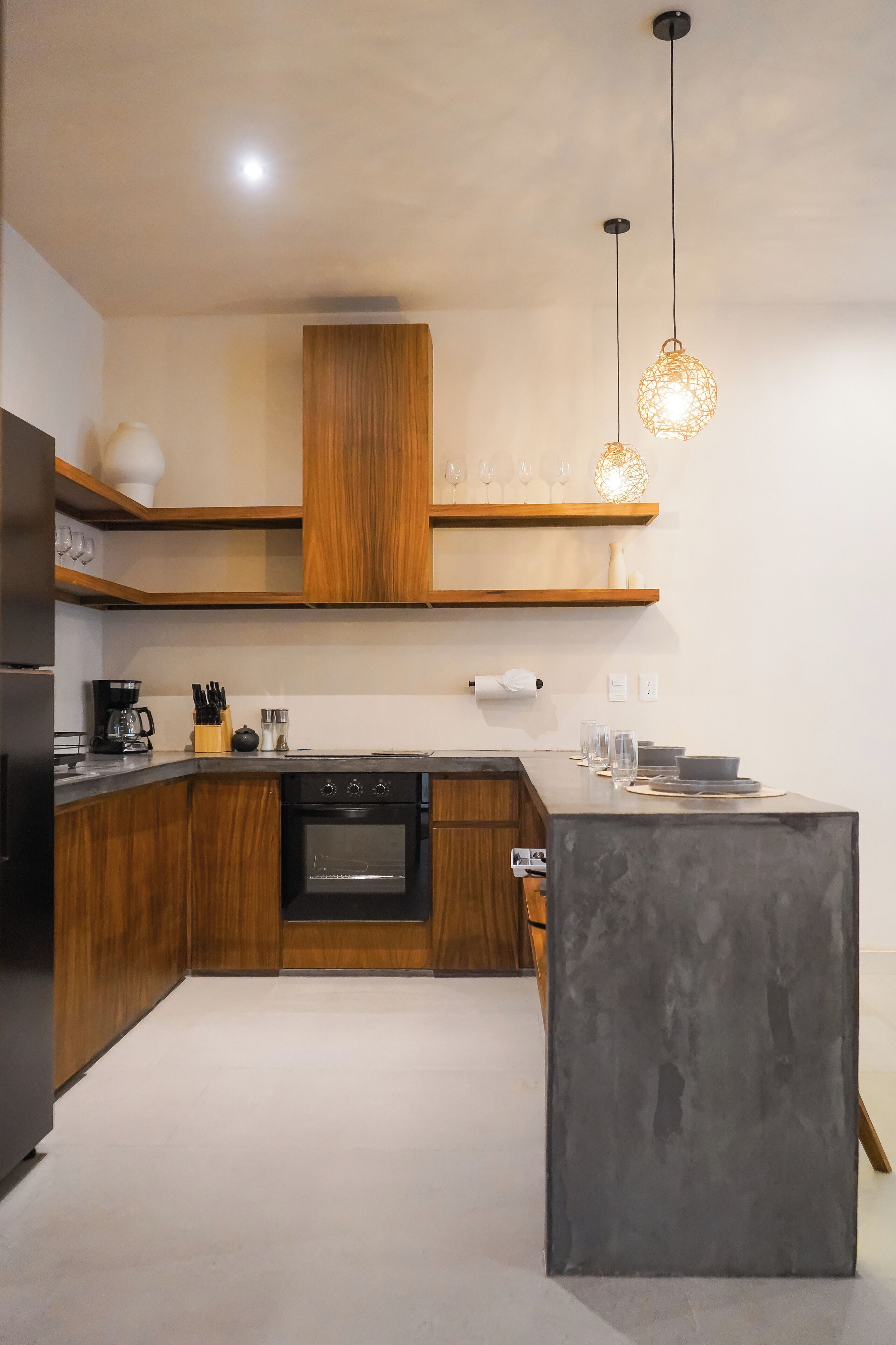 A modern kitchen with wooden cabinets, a built-in oven, and a large island.