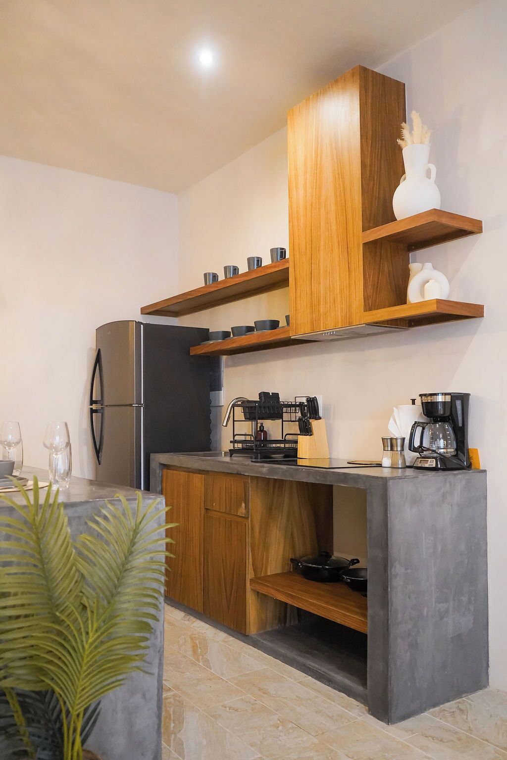 A modern kitchen with a built-in refrigerator, wooden cabinets, and a grey countertop.