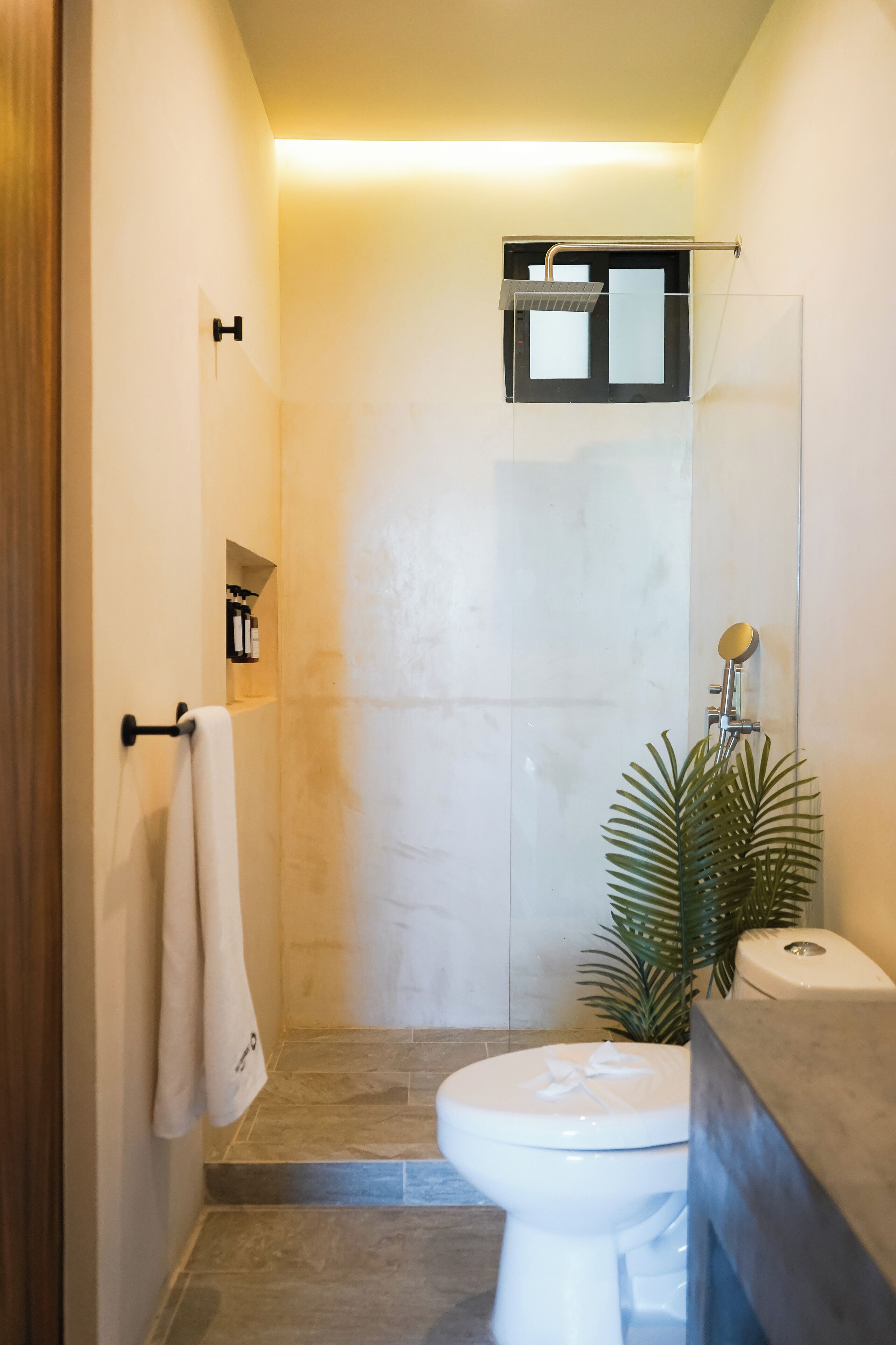 A modern bathroom with a shower, toilet, and sink.