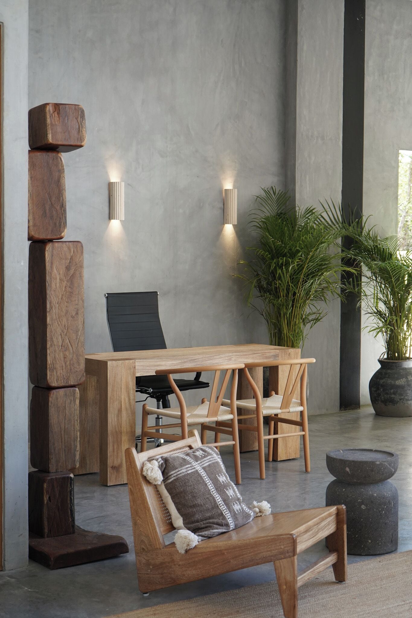 A modern interior with a wooden table, chairs, a bench, and two wall-mounted lights.