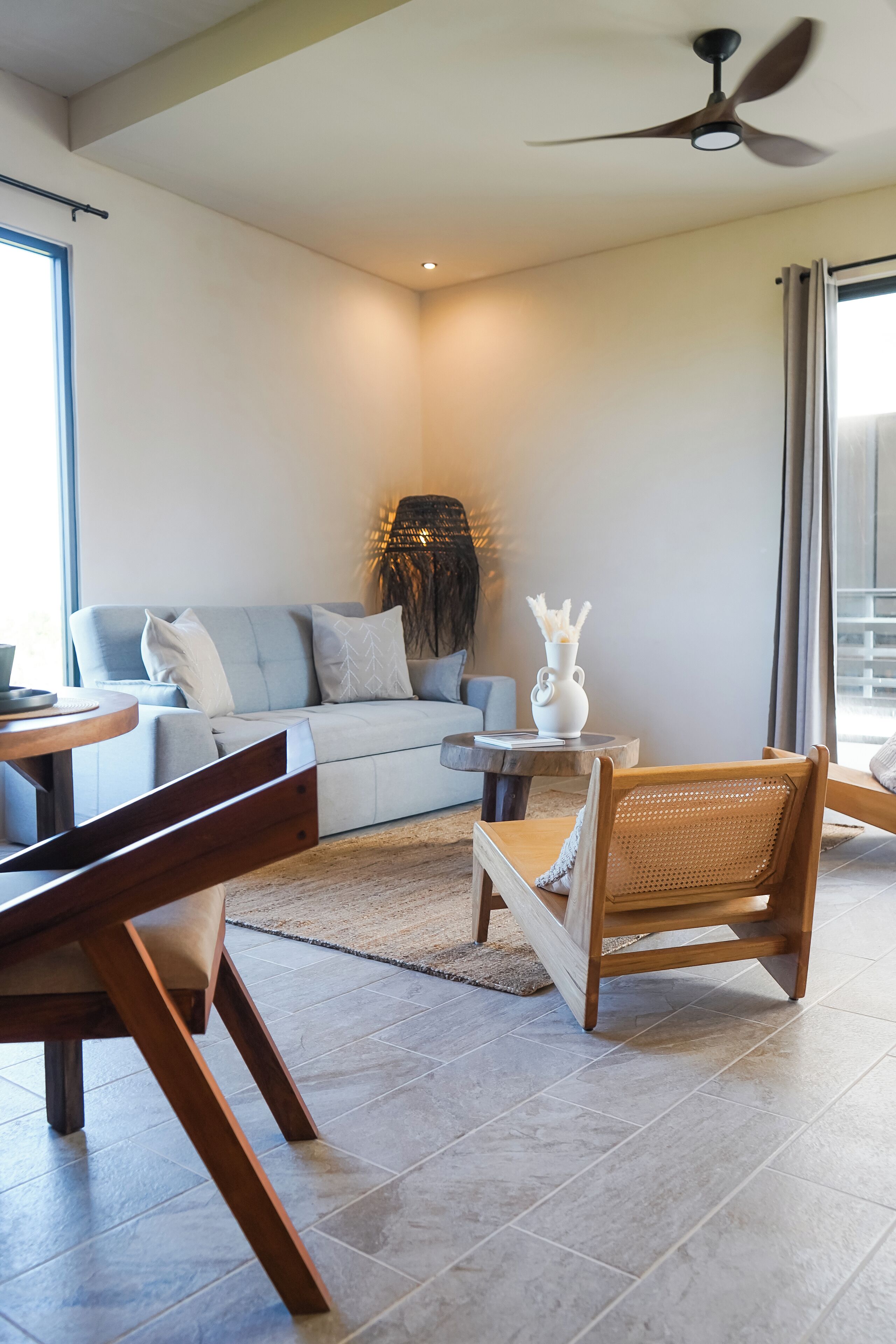 A modern living room with a sofa, coffee table, and a dining area with a chair.