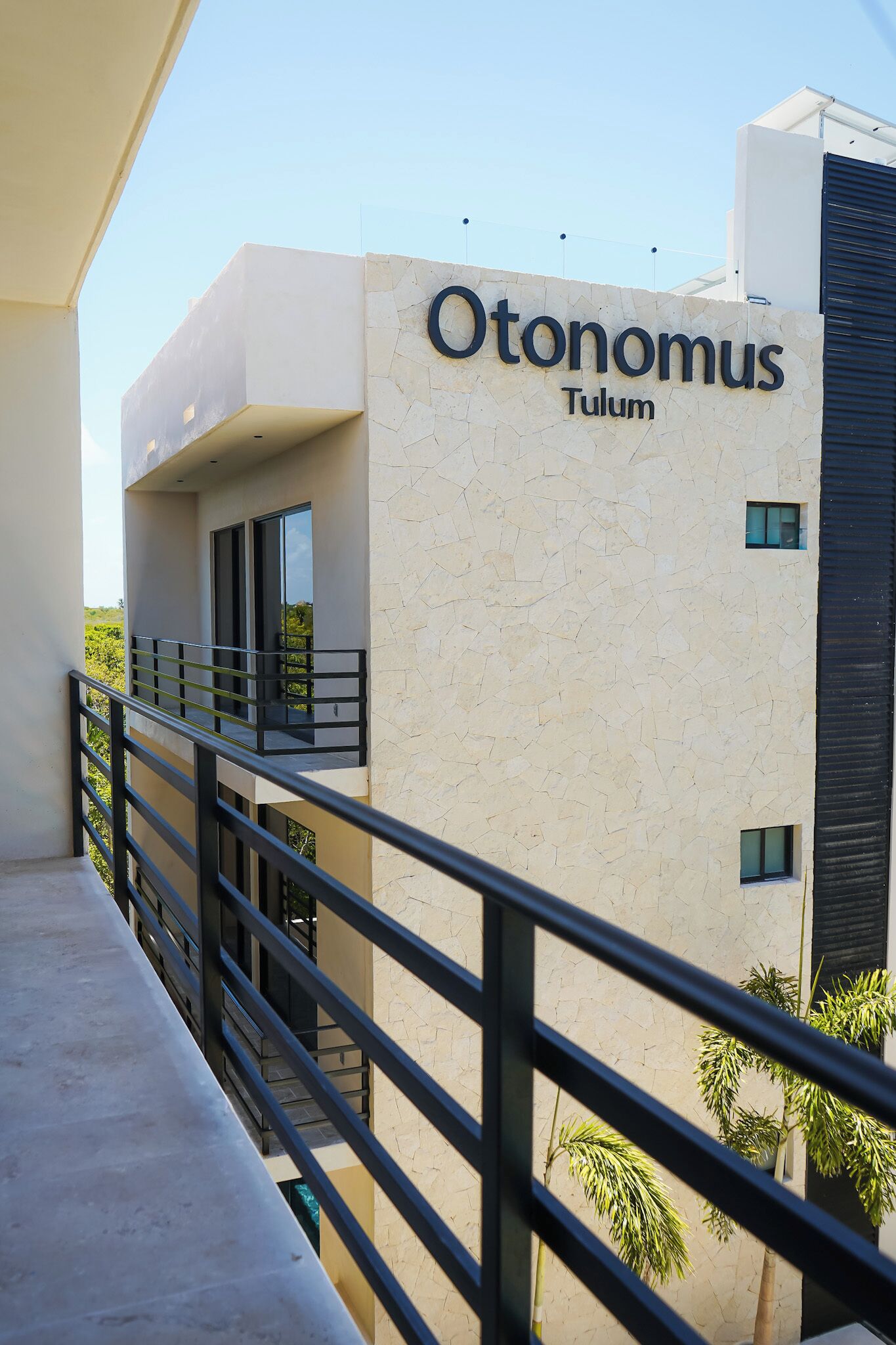 Un edificio moderno con un cartel que dice "Otonomus Tulum".