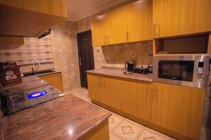 Appartement Deluxe, balcon, vue ville | Cuisine privée | Réfrigérateur, micro-ondes, four, plaque de cuisson