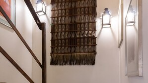 Un escalier avec une rampe en bois, une décoration murale à motifs et des appliques murales.