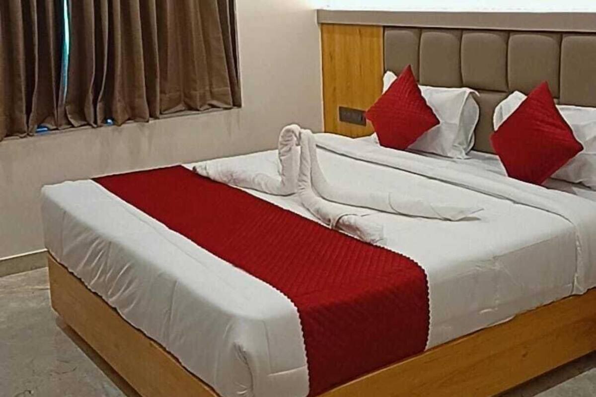 Une chambre d’hôtel avec un grand lit, un ventilateur de plafond, un appareil de climatisation et un mur à texture.