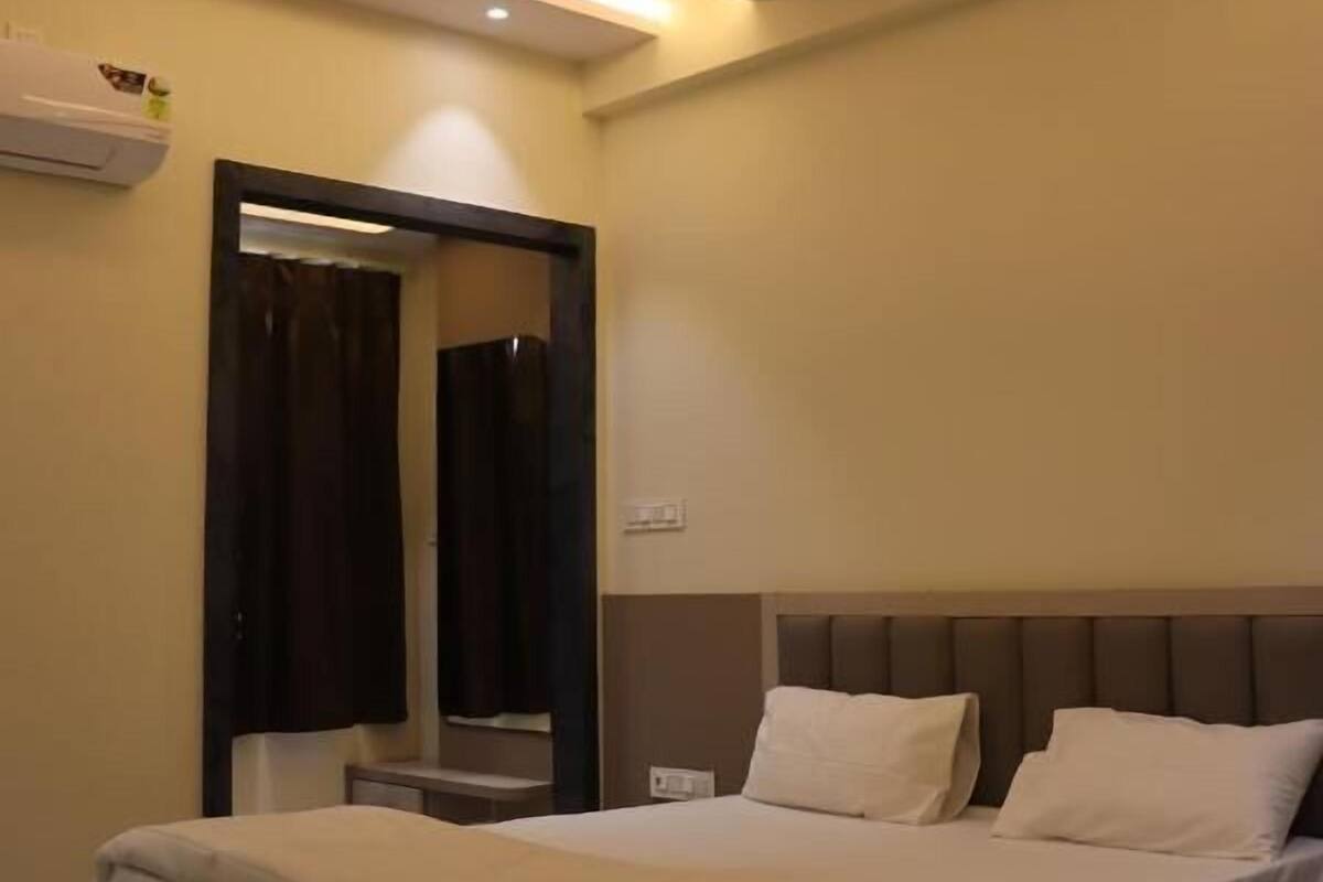 A modern bedroom with a bed, bedside tables, a ceiling fan, and a mirror.