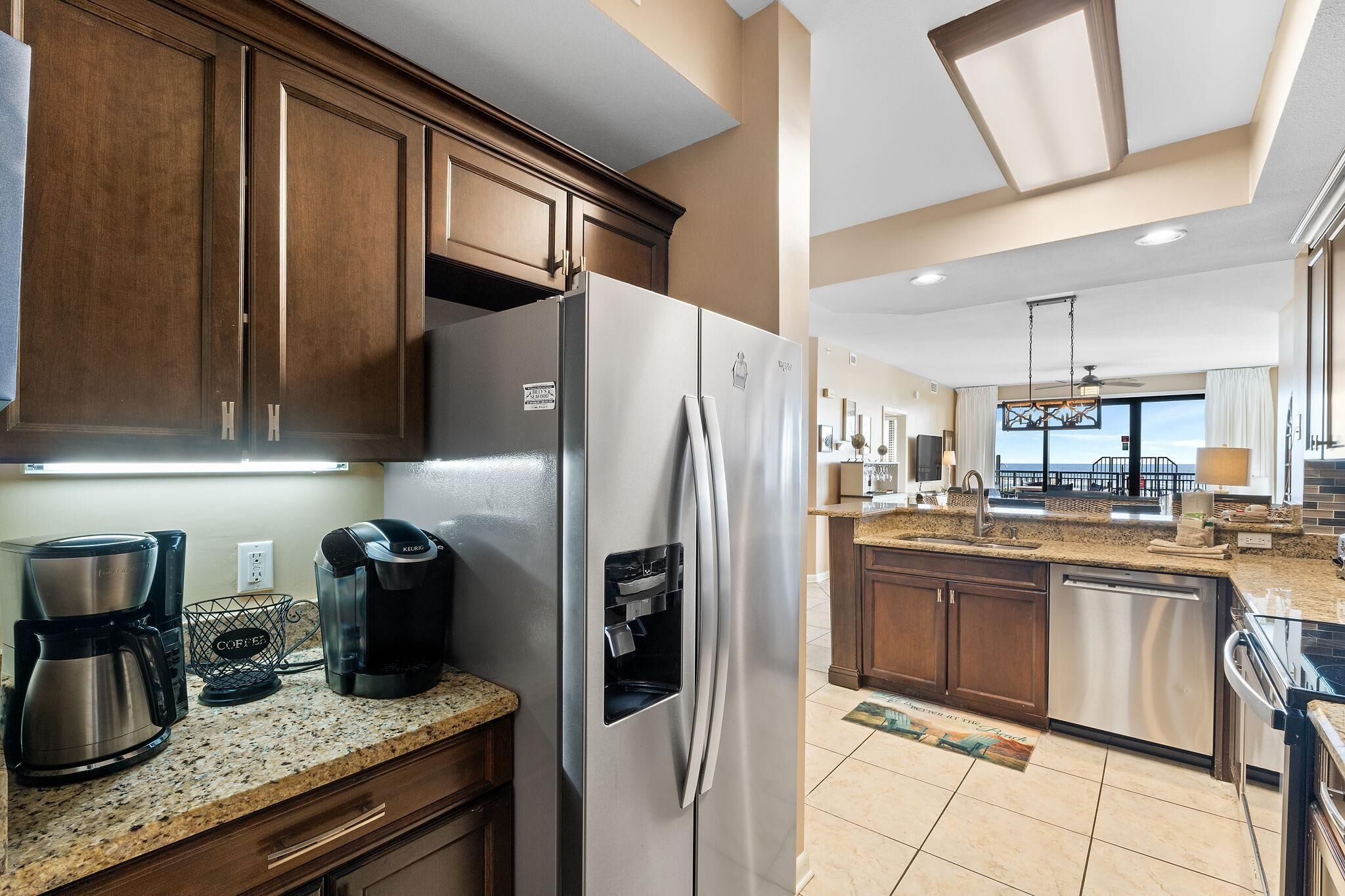 A modern kitchen with a stainless steel refrigerator, coffee maker, and a built-in water dispenser.