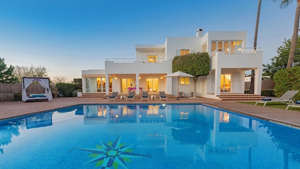 Una casa moderna de dos pisos con piscina, mobiliario exterior y una zona cubierta.