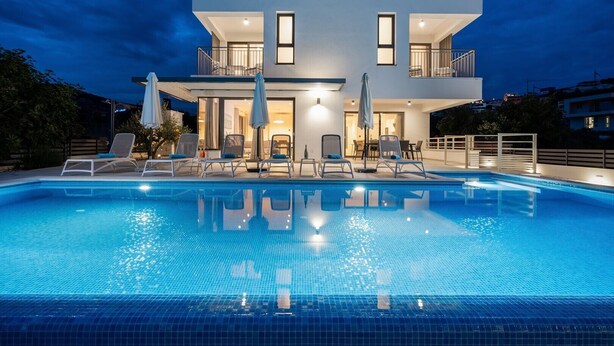 A modern two-story house with a swimming pool, lounge chairs, and umbrellas. - Villa Consido, a 3-Bedroom Retreat with sea views (Seget Vranjica)