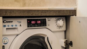A front-loading washing machine with a digital display and control panel.