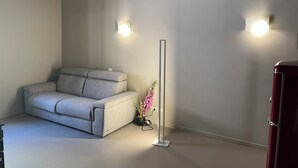 A modern living room with a grey sofa, a tall floor lamp, and a red cabinet. - Maison Chic Two, a stone's throw from the Spanish Steps (Roma)