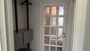A white door with six glass panels, a coat rack, and a built-in bench. - Maison Chic Two, a stone's throw from the Spanish Steps (Roma)