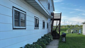 A house with a covered porch and a small outdoor grill. - Charming 3 room apartment with WiFi , AC in lovely Aurora.  (Aurora)