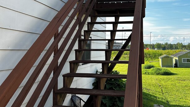 A wooden staircase leading to a white house with a clear blue sky in the background. - Charming 3 room apartment with WiFi , AC in lovely Aurora.  (Aurora)