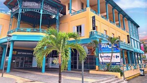 A building with a blue and yellow facade, a covered area labeled 'DREAM', and a sign for 'ATC Les Options'. - T2 au Confort tropical downtown! (Fort-de-France)