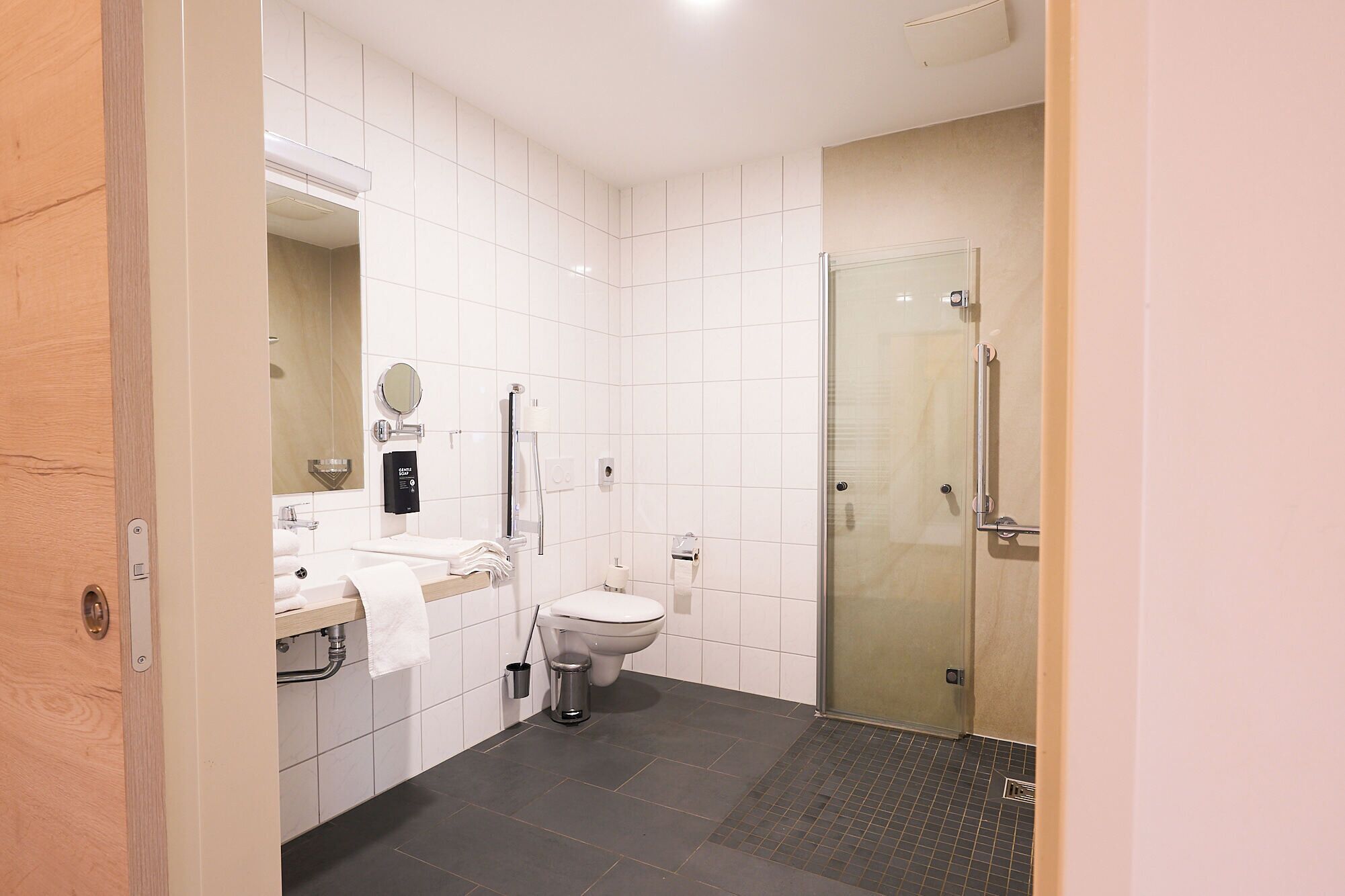 A modern bathroom with a toilet, sink, and shower.
