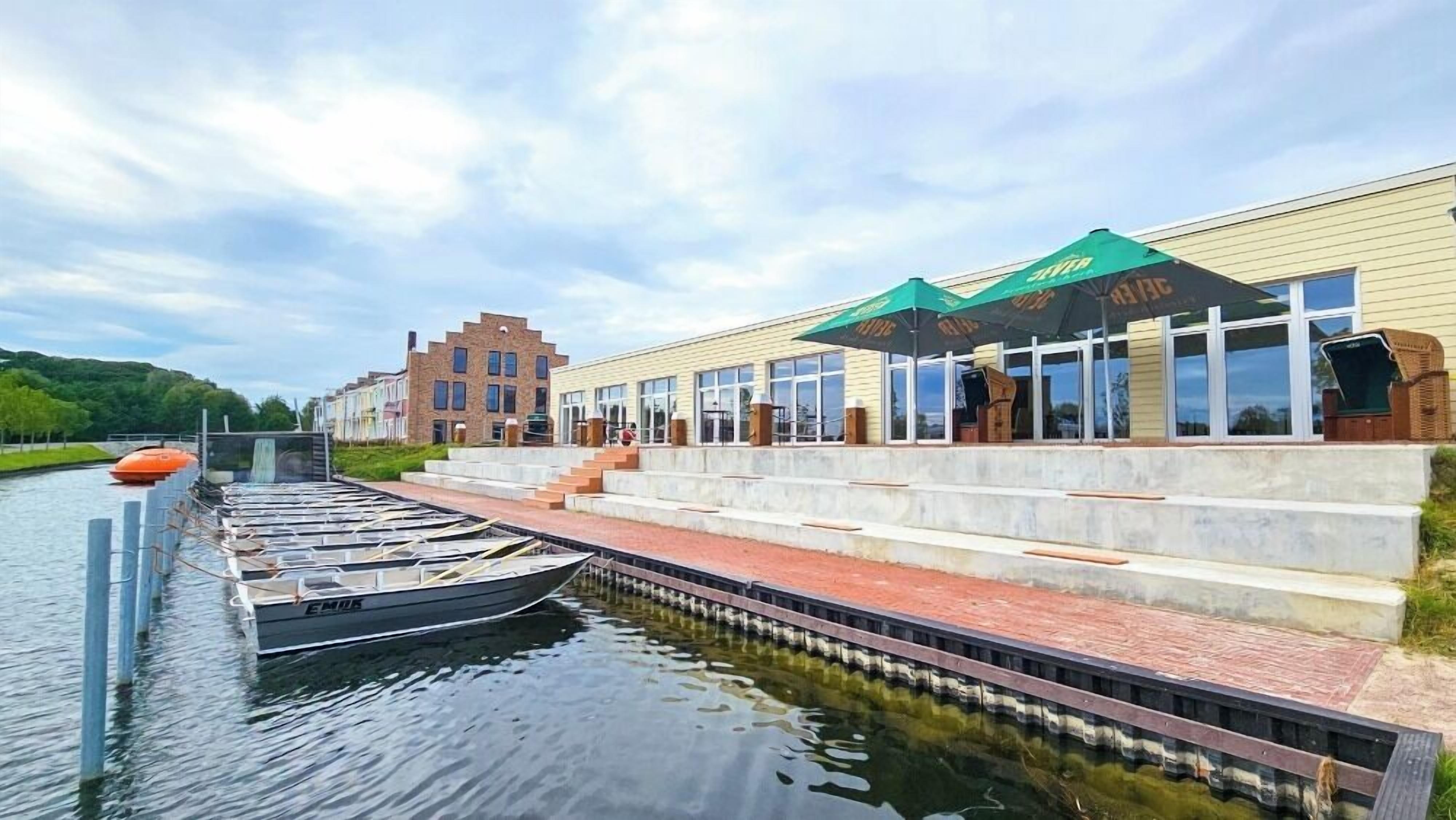 Un bâtiment situé au bord de la rivière, doté d’une terrasse et d’un quai pour bateaux.