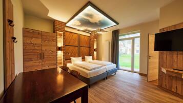 A bedroom with a bed, wooden furniture, a TV, and a skylight.