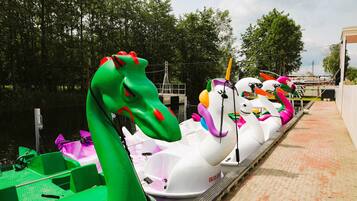 A row of watercraft with animal-shaped seats, docked at a pier.