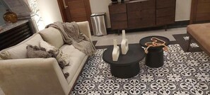 Un salon avec un canapé, une table basse et un sol à motifs.