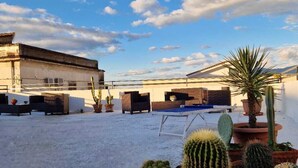 Une cour intérieure agrémentée de différents cactus en pot et d’une table de ping-pong.