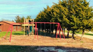 Ein Spielplatz mit Schaukeln und einer Kletteranlage.