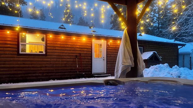A log cabin with a hot tub, surrounded by snow, and string lights above. - NEW LISTING! Ski, Play, Stay @ The Lodge is loaded! Hot tub, BBQ, sleeps 10,  (Naches)