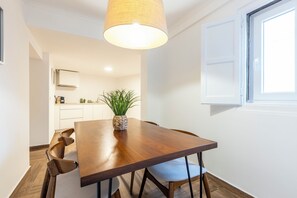 Enjoy meals in this inviting dining area with a wooden table and natural light pouring in through the window.
