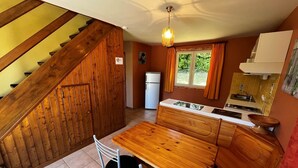 Une cuisine de taille réduite, dotée de meubles en bois, d’une cuisinière encastrée et d’un réfrigérateur.