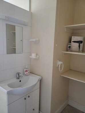 Bathroom features a sink, mirror, towel dispenser, and hair dryer.